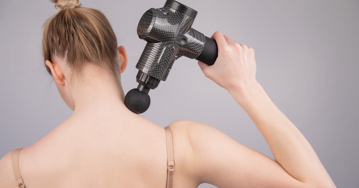 Kvinde bruger massagepistol